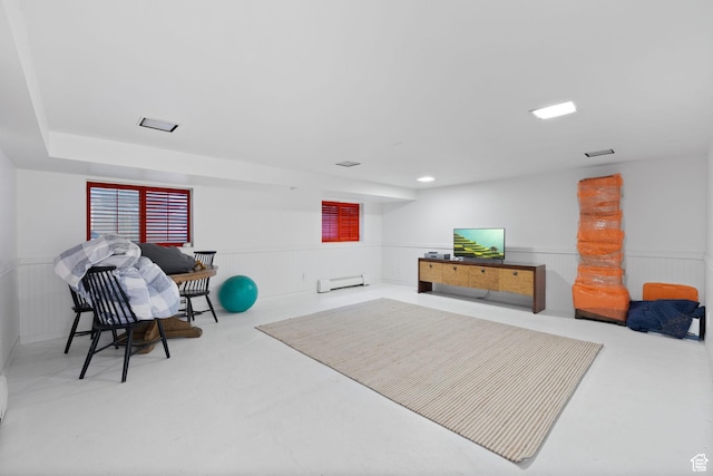 misc room with a baseboard radiator, a wainscoted wall, and finished concrete flooring