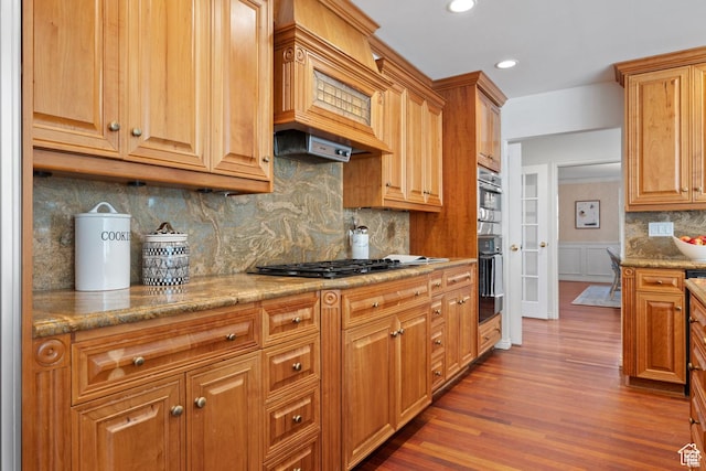 kitchen with black gas stovetop, dark wood-style floors, custom exhaust hood, backsplash, and recessed lighting