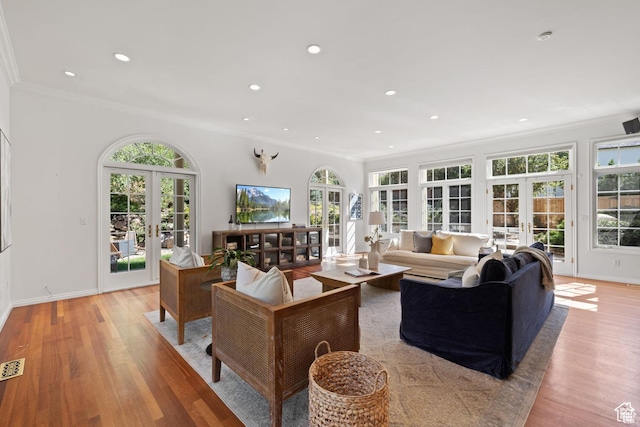living room featuring french doors, ornamental molding, plenty of natural light, recessed lighting, and light wood finished floors