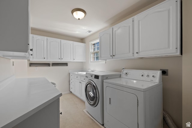 washroom with washing machine and clothes dryer, cabinet space, baseboards, and light carpet