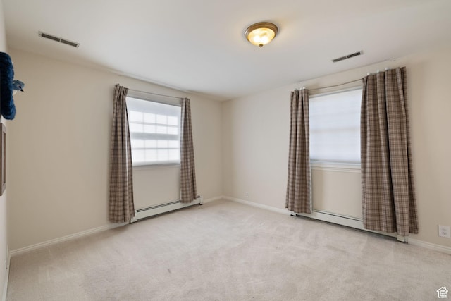 spare room with a baseboard heating unit, baseboards, and carpet floors