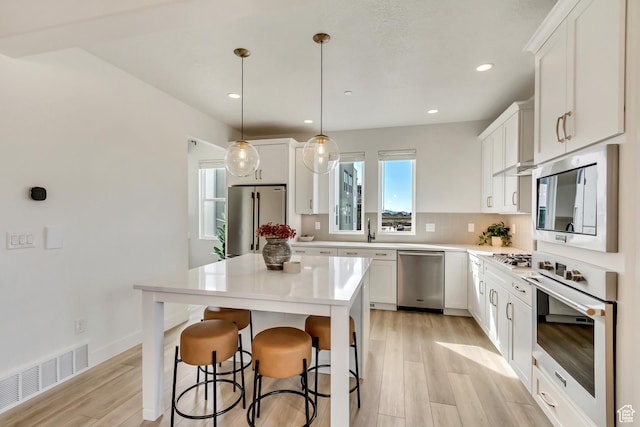 1474 W Cook Ln N Unit 163, Farmington, UT 84025 - kitchen featuring stainless steel appliances, light wood-type flooring, white cabinets, and recessed lighting