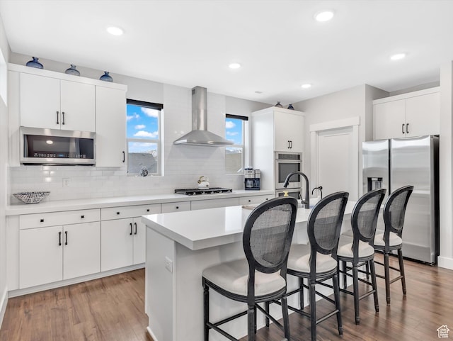 1374 Gambel Oak Way, Park City, UT 84098 - kitchen with appliances with stainless steel finishes, wall chimney exhaust hood, a kitchen breakfast bar, backsplash, and light countertops