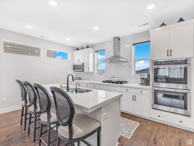 1374 Gambel Oak Way, Park City, UT 84098 - kitchen with wall chimney exhaust hood, appliances with stainless steel finishes, a sink, a breakfast bar, and recessed lighting