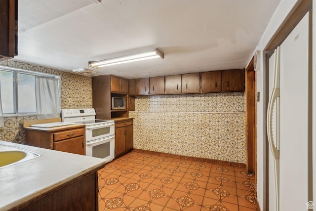 1435 S 500 E, Salt Lake City, UT 84105 - kitchen with range with two ovens, stainless steel microwave, light countertops, and brown cabinets
