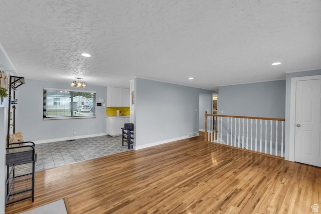 492 W Highland Dr, Riverdale, UT 84405 - unfurnished living room with a textured ceiling, wood finished floors, a chandelier, baseboards, and recessed lighting