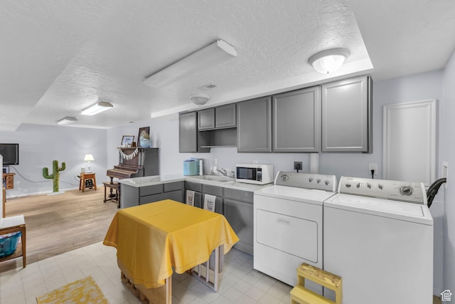 492 W Highland Dr, Riverdale, UT 84405 - clothes washing area featuring washer and dryer, a textured ceiling, light floors, and baseboards