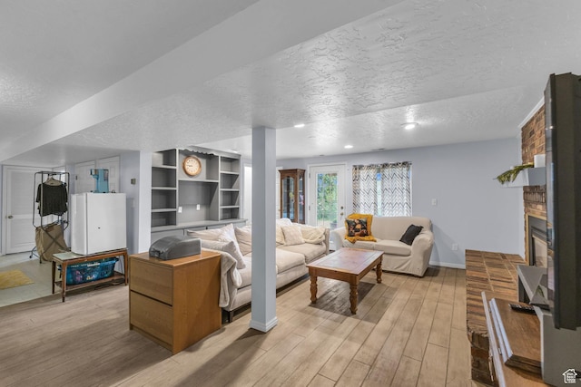 492 W Highland Dr, Riverdale, UT 84405 - living room featuring a textured ceiling, light wood-style flooring, a fireplace, baseboards, and recessed lighting