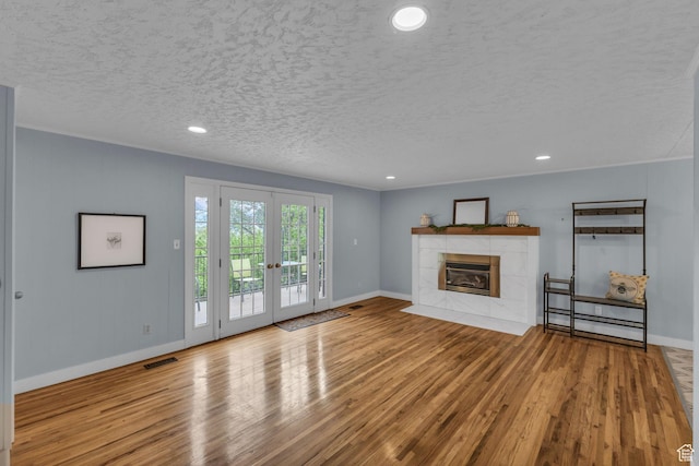 492 W Highland Dr, Riverdale, UT 84405 - unfurnished living room with wood finished floors, baseboards, french doors, a fireplace, and a textured ceiling