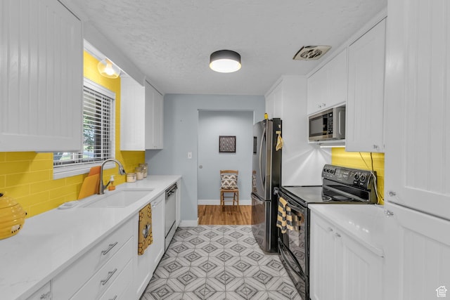 492 W Highland Dr, Riverdale, UT 84405 - kitchen featuring appliances with stainless steel finishes, a sink, white cabinetry, baseboards, and light countertops