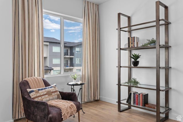 sitting room featuring wood finished floors, plenty of natural light, and baseboards