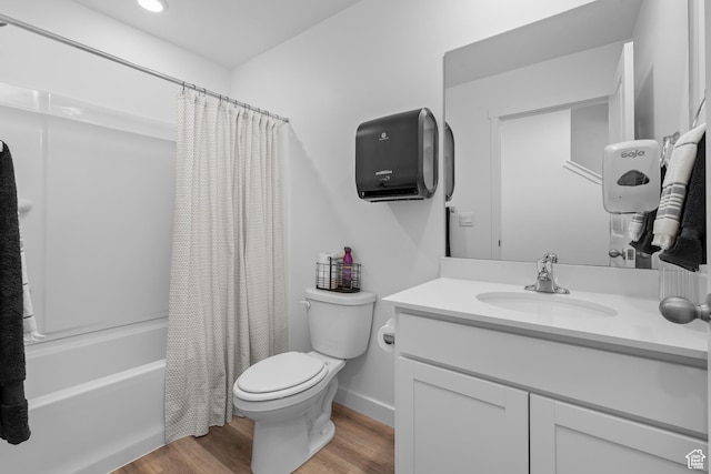 full bathroom with wood finished floors, toilet, vanity, and shower / tub combo
