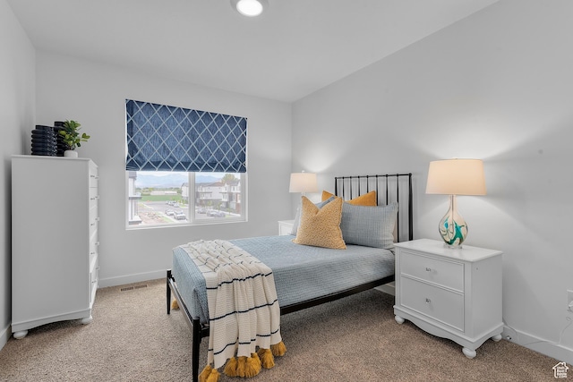 bedroom featuring light carpet and baseboards