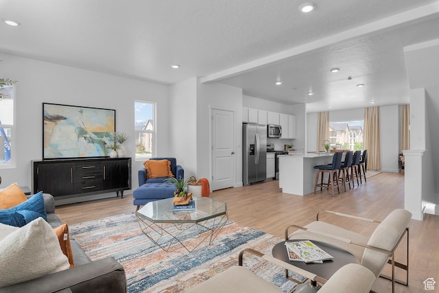 living area featuring light wood-type flooring and recessed lighting