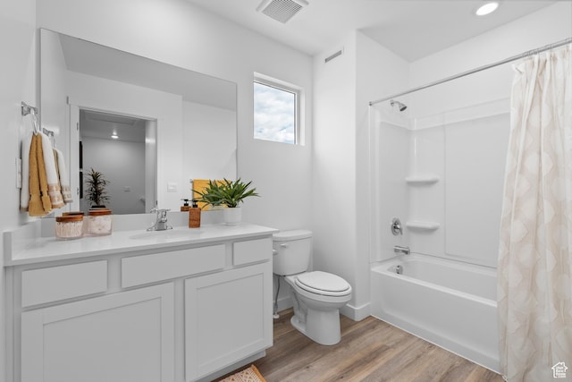 bathroom with wood finished floors, toilet, vanity, and shower / bath combo with shower curtain