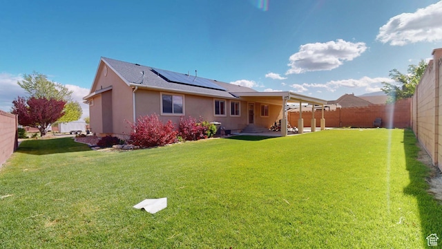 rear view of house with solar panels and stucco siding