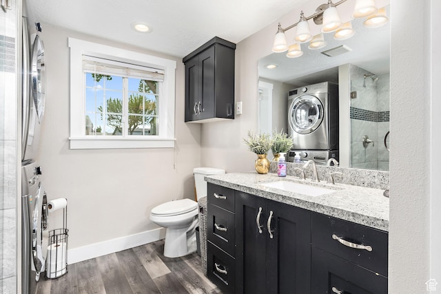 2119 W 12190 S, Riverton, UT 84065 - bathroom with stacked washer and clothes dryer, toilet, baseboards, wood finished floors, and vanity