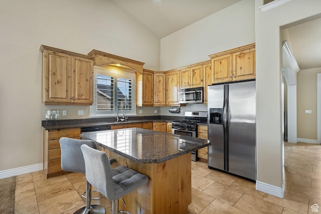 kitchen with stainless steel appliances, high vaulted ceiling, a sink, a kitchen island, and a kitchen breakfast bar