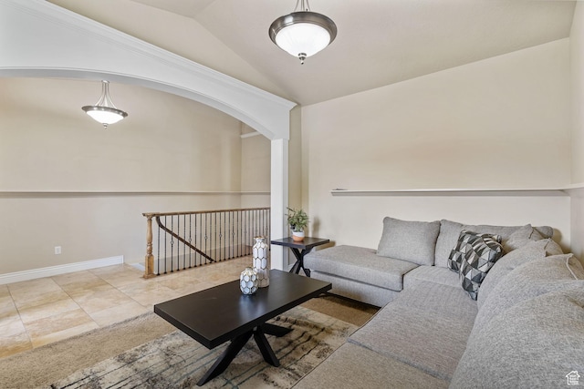 tiled living area with arched walkways, lofted ceiling, and baseboards