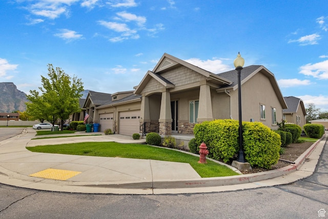 craftsman inspired home featuring a garage, stucco siding, concrete driveway, stone siding, and a front yard