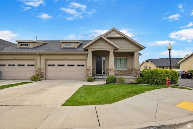view of front of home with stone siding, stucco siding, concrete driveway, and a front yard