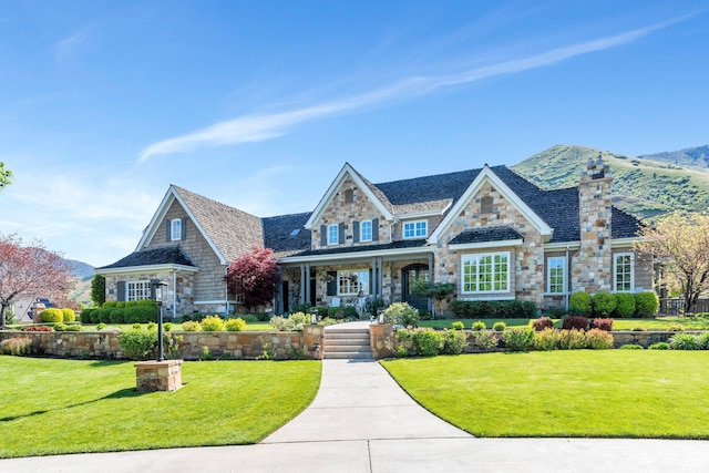 575 S 1560 E, Mapleton, UT 84664 - view of front facade with stone siding, covered porch, a front yard, a chimney, and a mountain view