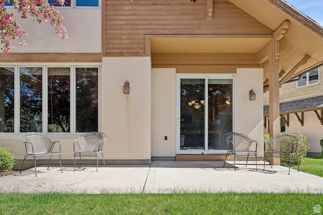 doorway to property with a patio area and stucco siding