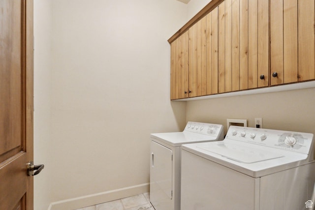 washroom featuring independent washer and dryer, baseboards, and cabinet space