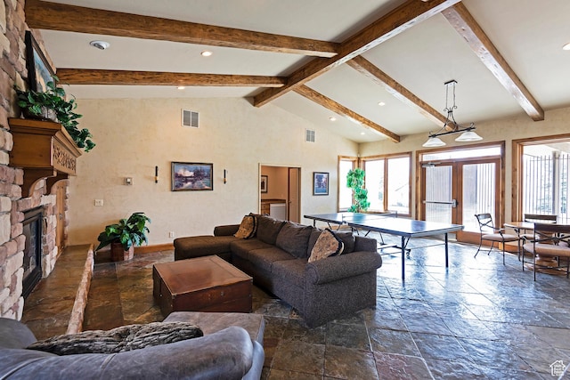 living room with stone tile floors, recessed lighting, a stone fireplace, and french doors