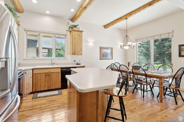 kitchen with stainless steel refrigerator with ice dispenser, light wood finished floors, healthy amount of natural light, beamed ceiling, and black dishwasher