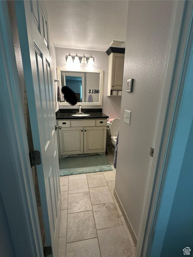 250 W 100 S, Duchesne, UT 84021 - bathroom featuring vanity, a textured ceiling, and toilet