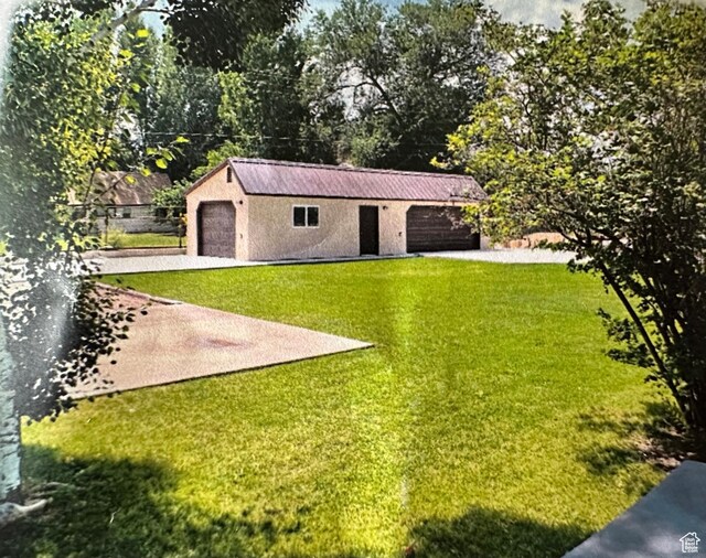 250 W 100 S, Duchesne, UT 84021 - view of grassy yard featuring an outbuilding, driveway, and a garage