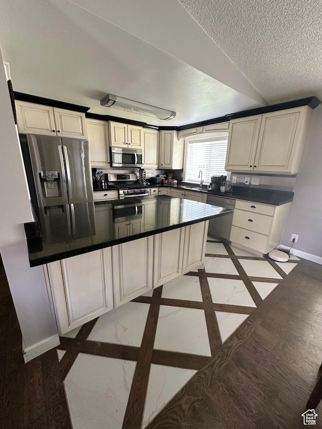 250 W 100 S, Duchesne, UT 84021 - kitchen with stainless steel appliances, baseboards, a textured ceiling, inlaid floor details, and dark countertops