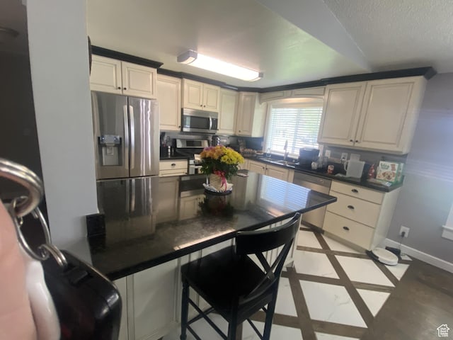 250 W 100 S, Duchesne, UT 84021 - kitchen with appliances with stainless steel finishes, dark countertops, inlaid floor details, baseboards, and a textured ceiling