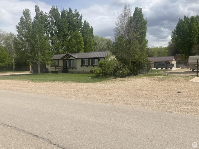 250 W 100 S, Duchesne, UT 84021 - view of front of house with metal roof, driveway, a garage, and a front lawn