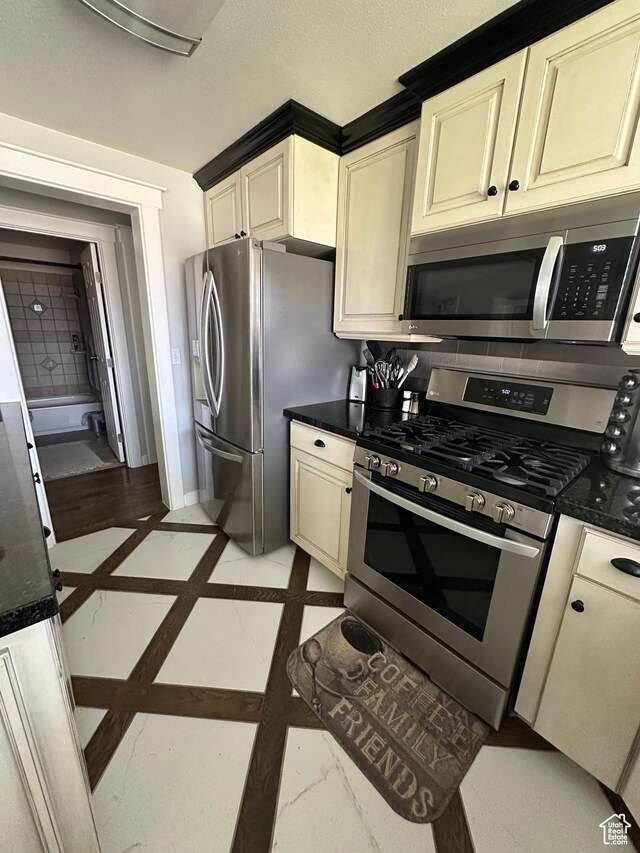 250 W 100 S, Duchesne, UT 84021 - kitchen featuring appliances with stainless steel finishes, cream cabinets, inlaid floor details, and baseboards