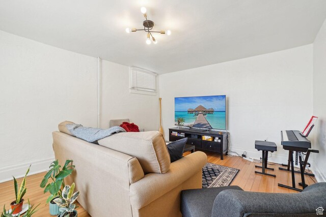 living room featuring light wood-style floors, a chandelier, and baseboards