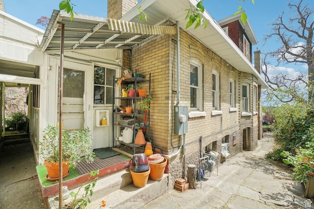 view of home's exterior featuring a chimney and brick siding