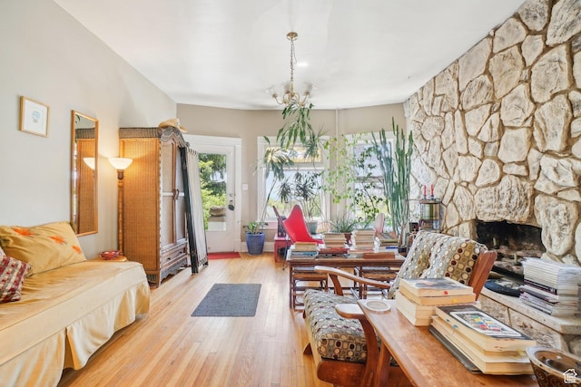 living room featuring light wood finished floors and a stone fireplace