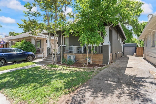 328 E Hampton Ave S, Salt Lake City, UT 84111 - view of front of house featuring a porch, brick siding, asphalt driveway, a front yard, and an outdoor structure
