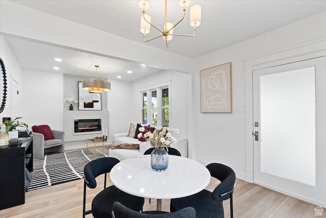 328 E Hampton Ave S, Salt Lake City, UT 84111 - dining room with a glass covered fireplace, a chandelier, light wood finished floors, and recessed lighting