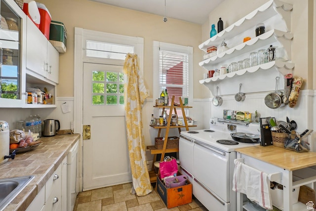 538 S 800 E, Salt Lake City, UT 84102 - kitchen with white range with electric stovetop, open shelves, wainscoting, white cabinetry, and stone finish flooring