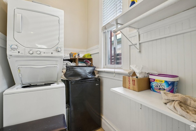 538 S 800 E, Salt Lake City, UT 84102 - laundry room featuring stacked washer and clothes dryer, a wainscoted wall, and a decorative wall