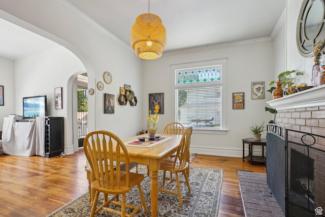 538 S 800 E, Salt Lake City, UT 84102 - dining space with arched walkways, wood finished floors, a fireplace, crown molding, and baseboards