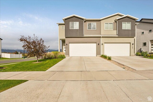7881 S Highlandpoint Way, West Jordan, UT 84081 - view of front of home featuring an attached garage, driveway, a front lawn, and stucco siding