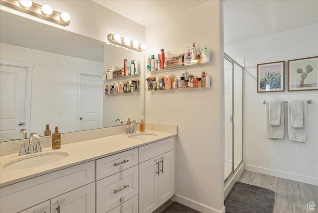 7881 S Highlandpoint Way, West Jordan, UT 84081 - full bathroom featuring wood finished floors, a shower stall, double vanity, and baseboards