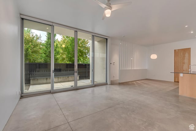 608 S 400 E, Salt Lake City, UT 84111 - empty room featuring finished concrete flooring, expansive windows, plenty of natural light, and a ceiling fan