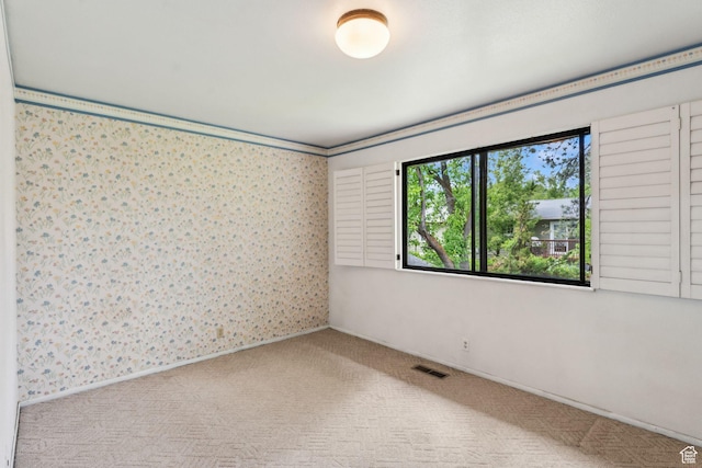 carpeted empty room with wallpapered walls