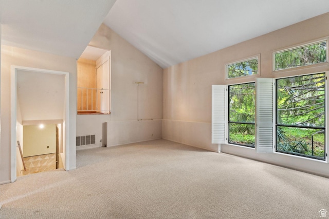 unfurnished room with carpet flooring and lofted ceiling