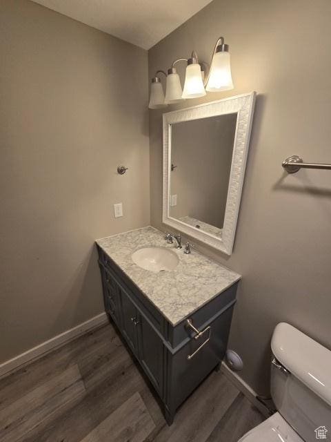 834 N Sapphire St, Morgan, UT 84050 - half bathroom featuring wood finished floors, baseboards, vanity, and toilet